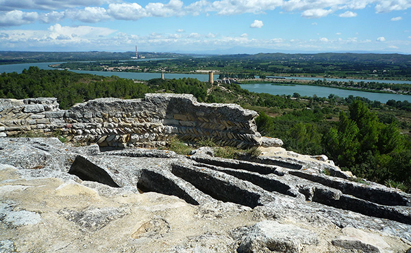 1200px-Abbaye_de_Saint-Roman_sur_une_colline_au-dessus_du_Rhône